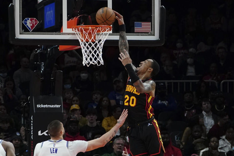 Atlanta Hawks' John Collins scores as Sacramento Kings center Alex Len (25) defends in the second half of an NBA basketball game Wednesday, Jan. 26, 2022, in Atlanta. (AP Photo/John Bazemore)