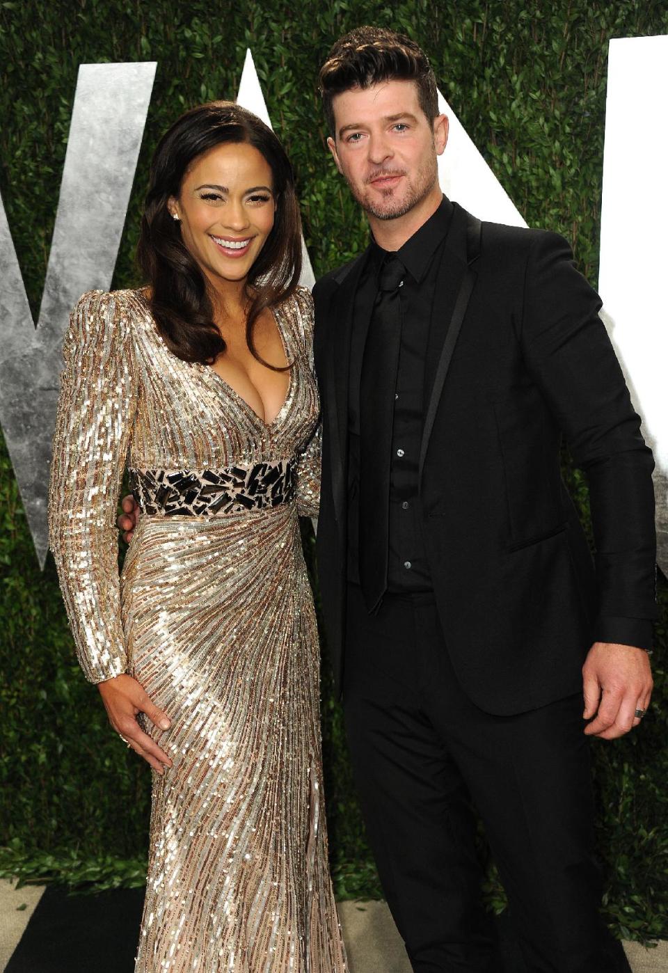 FILE - In this Feb. 24, 2013 file photo, Paula Patton and Robin Thicke arrive at the 2013 Vanity Fair Oscars Viewing and After Party at the Sunset Plaza Hotel in West Hollywood, Calif. Patton is busy promoting her second film this year, the upcoming romantic comedy “Baggage Claim.” Personally, Patton is relishing the success of her recording artist husband Thicke, whose catchy summer hit “Blurred Lines” has topped Billboard's Hot 100 chart. (Photo by Jordan Strauss/Invision/AP, File)