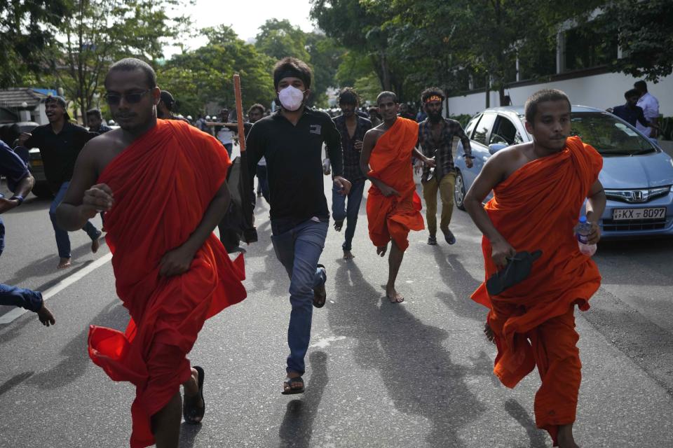 Anti-government protesters run as police chase them during a protest march in Colombo, Sri Lanka, Thursday, Aug. 18, 2022. (AP Photo/Eranga Jayawardena)