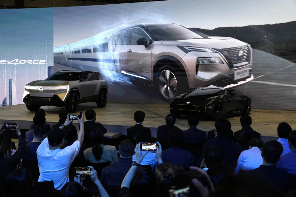 Attendees watch a presentation at the Nissan booth during the Auto Shanghai 2023 show in Shanghai, Tuesday, April 18, 2023. Global and Chinese automakers plan to unveil more than a dozen new electric SUVs, sedans and muscle cars this week at the Shanghai auto show, their first full-scale sales event in four years in a market that has become a workshop for developing electrics, self-driving cars and other technology. (AP Photo/Ng Han Guan)