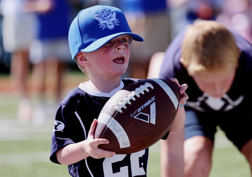 Carson Campbell carries a football as he plays on the outdoor practice field as BYU holds a party to celebrate their move into the Big 12 Conference with music, games and sports exhibits in Provo on Saturday, July 1, 2023. | Scott G Winterton, Deseret News