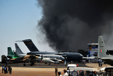 Smoke billows past a row of parked planes after a fire broke out in a parking lot during the Aero India show at the Yelahanka Air Force Station in Bengaluru, India, February 23, 2019. REUTERS/Stringer