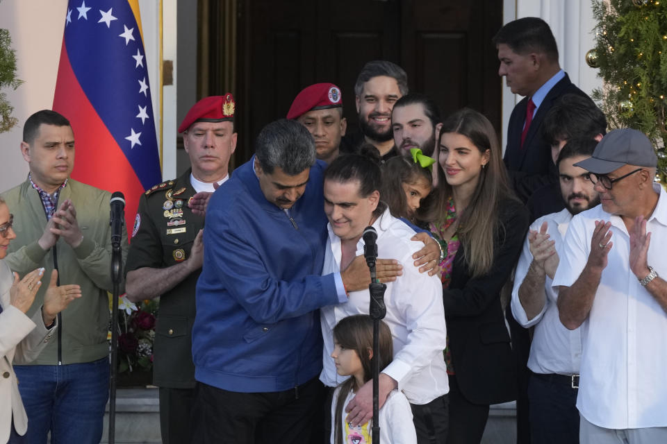 Venezuelan President Maduro, center left, embraces Alex Saab after Saab arrived at Miraflores presidential palace in Caracas, Venezuela, Wednesday, Dec. 20, 2023. The United States freed Saab, who was arrested on a U.S. warrant for money laundering in 2020, in exchange for the release of 10 Americans imprisoned in Venezuela, the Biden administration announced Wednesday. Saab's young daughter Mariam stands in front of him, wife Camila Fabri stands center right, sons Isham, behind, Shadi, right, and Charlotte partially covered behind Shadi. (AP Photo/Matias Delacroix)