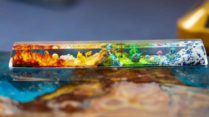 A bespoke Pokemon spacebar, made with resin, featuring a diorama of monsters in their environment.