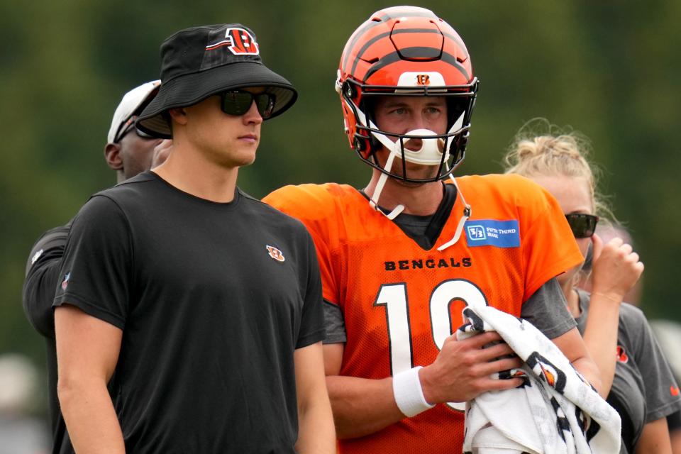 Cincinnati Bengals quarterback Joe Burrow (9), left, talks with Cincinnati Bengals quarterback Trevor Siemian (19), right, during a joint practice between the Green Bay Packers and the Cincinnati Bengals, Wednesday, Aug. 9, 2023, at the practice fields next to Paycor Stadium in Cincinnati.