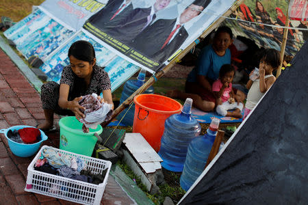 A family stay at a camp for displaced earthquake and liquefaction victims in Palu, Central Sulawesi, Indonesia, October 12, 2018. REUTERS/Jorge Silva