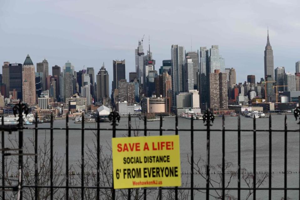 A sign hangs in a park overlooking the Manhattan skyline as seen from Weehawken, New Jersey.