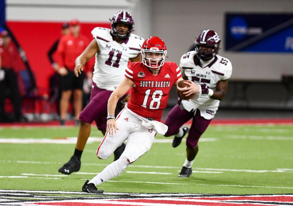 South Dakota's Carson Camp runs the ball as he is chased by Southern Illinois' Avante Cox and Kholbe Coleman during their FCS playoff game on Saturday, November 27, 2021, at the DakotaDome in Vermillion.