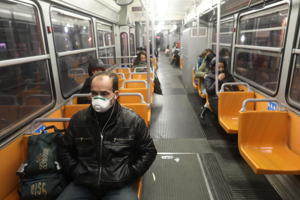 A single passenger using public transport wears a protective mask.