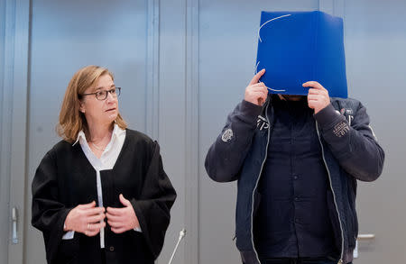 Former nurse Niels Hoegel covers his face as he arrives for the start of his trial in a courtroom in Oldenburg, Germany, October 30, 2018. Julian Stratenschulte/Pool via REUTERS