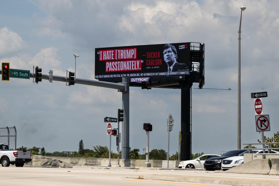 A billboard on April 3 near former President Donald Trump's Mar-a-Lago estate in Palm Beach, Fla., quotes Tucker Carlson's private text message, made public in court filings.