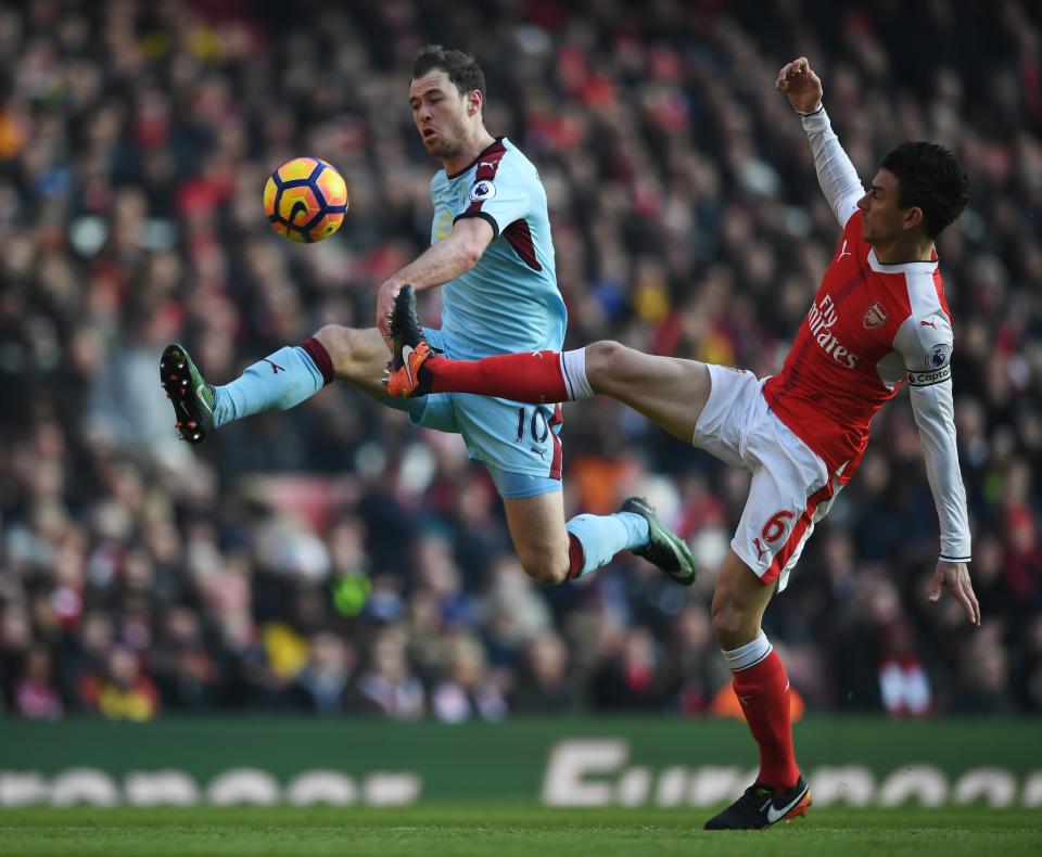 <p>Laurent Koscielny tries to stop Ashley Barnes </p>