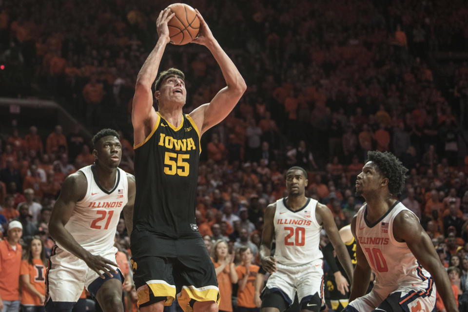 Iowa's Luka Garza (55) shoots as Illinois' Kofi Cockburn (21), Da'Monte Williams (20), and Andres Feliz (10) defend in the second half of an NCAA college basketball game Sunday, March 8, 2020, in Champaign, Ill. (AP Photo/Holly Hart)