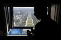 A visitor looks out toward the U.S. Capitol from the Washington Monument's observation level during a press preview tour ahead of the monument's official reopening, Wednesday, Sept. 18, 2019, in Washington. The monument, which has been closed to the public since August 2016, is scheduled to re-open Thursday, Sept. 19. (AP Photo/Patrick Semansky)