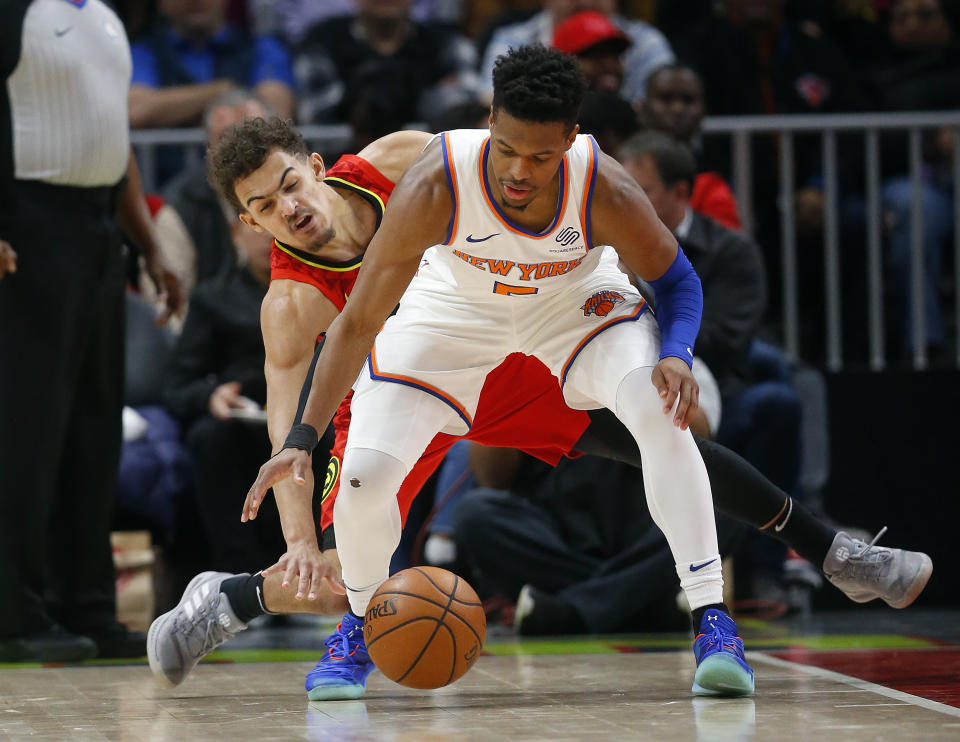 Atlanta Hawks guard Trae Young, rear, tries to steal the ball from New York Knicks guard Dennis Smith Jr. during the first half of an NBA basketball game Thursday, Feb. 14, 2019, in Atlanta. New York won 106-91. (AP Photo/John Bazemore)