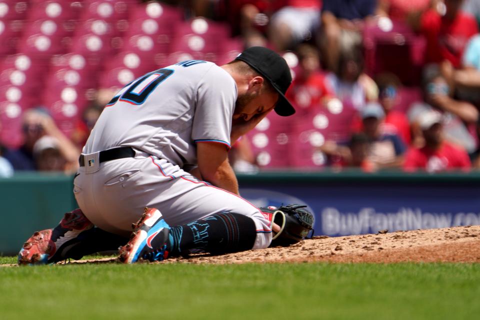 Miami Marlins starting pitcher Daniel Castano (20) falls to his knees after a ball off the bat of Cincinnati Reds third baseman Donovan Solano (7) (not pictured) was hit toward the mound during the first inning of a baseball game, Thursday, July 28, 2022, at Great American Ball Park in Cincinnati. 