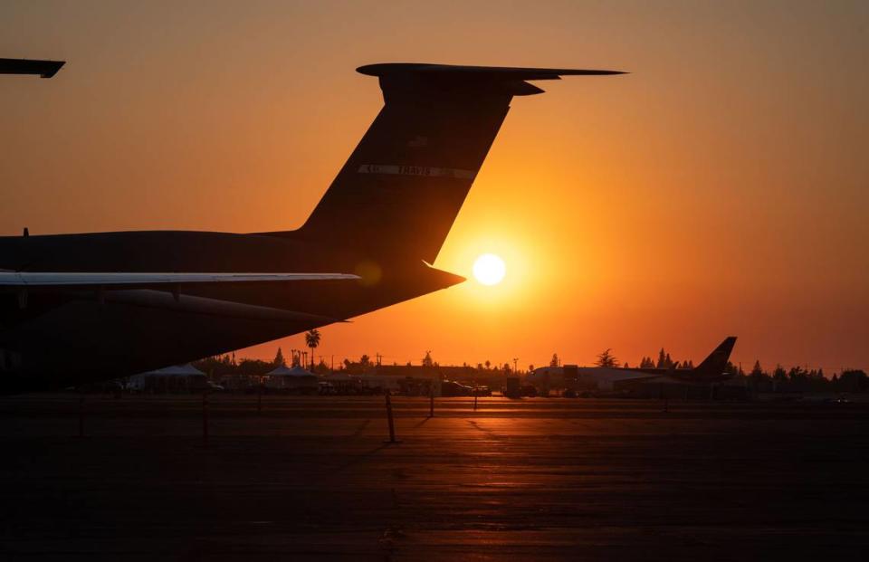 An Air Force C-5M Super Galaxy, left, out of Travis Air Force Base, sits with other planes at Mather Airport at sunset as the first day of the three-day California Capital Airshow wraps up Friday, Sept. 24, 2021, in Sacramento.