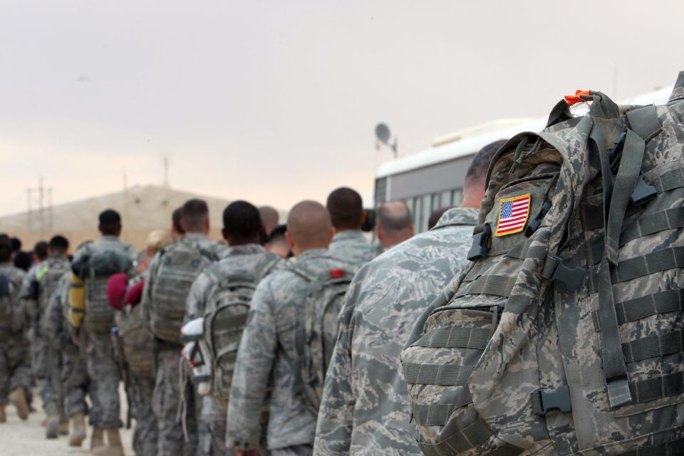 U.S. army soldiers line up to board a plane to begin their journey home out of Iraq from the Al-Asad Air base west of Baghdad, on Nov. 1, 2011.