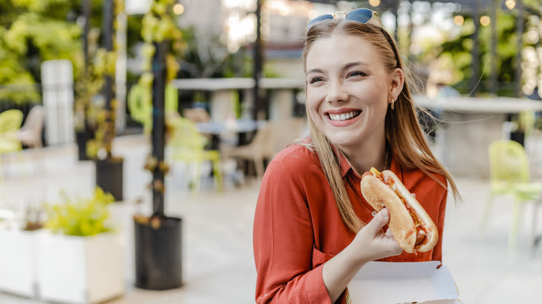 Woman holding a hot dog