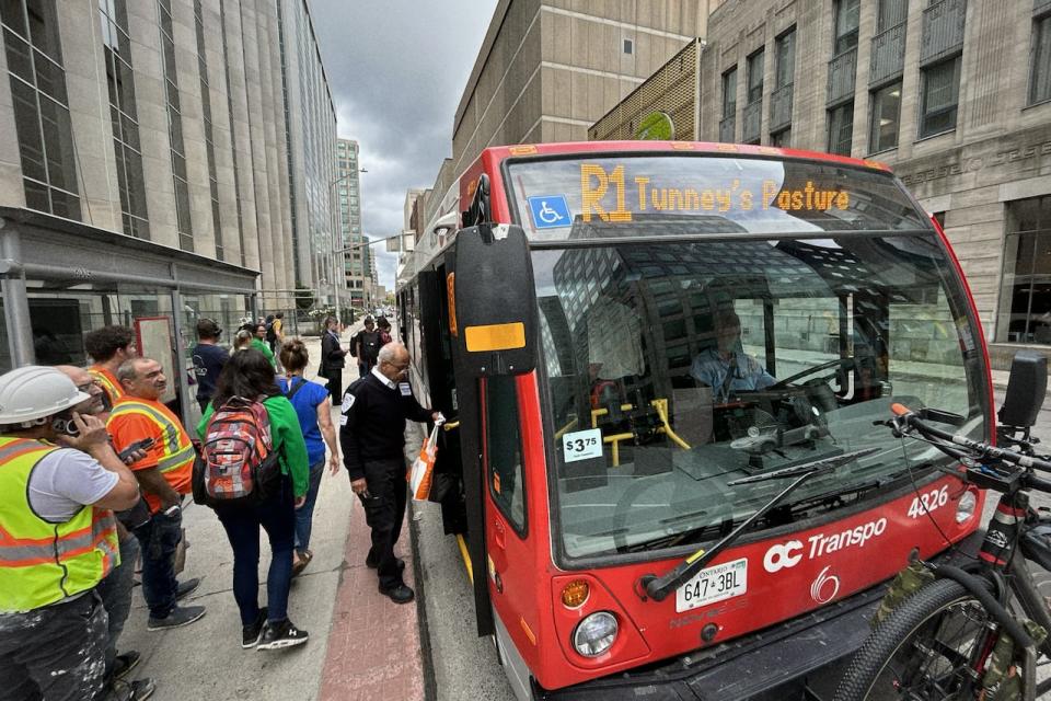 Ottawa commuters board OC Transpo R1 replacement bus in downtown