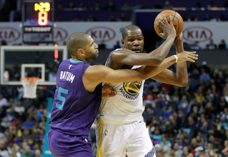 Kevin Durant of the Golden State Warriors tries to keep the ball from Nicolas Batum of the Charlotte Hornets, at Spectrum Center in Charlotte, North Carolina, on December 6, 2017