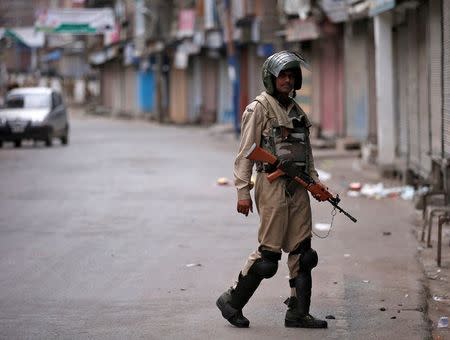 An Indian policeman stands guard in a deserted street during a curfew in Srinagar July 16, 2016. REUTERS/Danish Ismail