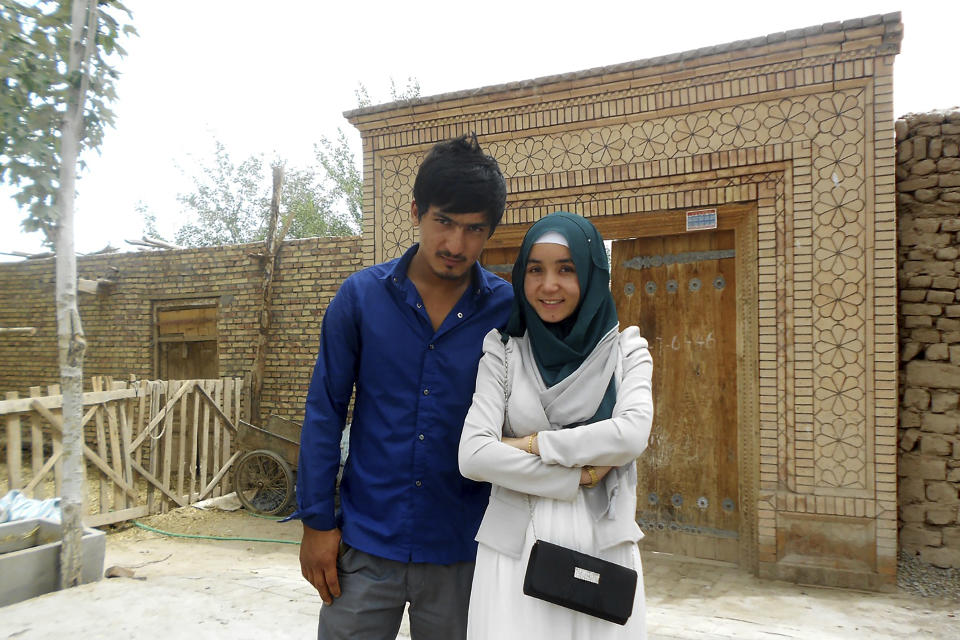 In this photo released by Nursimangul Abdureshid, Memetali Abdureshid poses for a picture with his sister Nursimangul Abdureshid outside their family home in Sayibage township in China's far west Xinjiang region in August 2013. Nearly one in 25 people in a county in the Uyghur heartland of China has been sentenced to prison on terrorism-related charges, in what is the highest known imprisonment rate in the world, an Associated Press review of leaked data shows. Memetali Abdureshid, who ran a car repair shop, was listed as being sentenced to 15 years and 11 months in prison on charges of "picking quarrels and provoking trouble” and “preparing to carry out terrorist activities." (Nursimangul Abdureshid via AP)