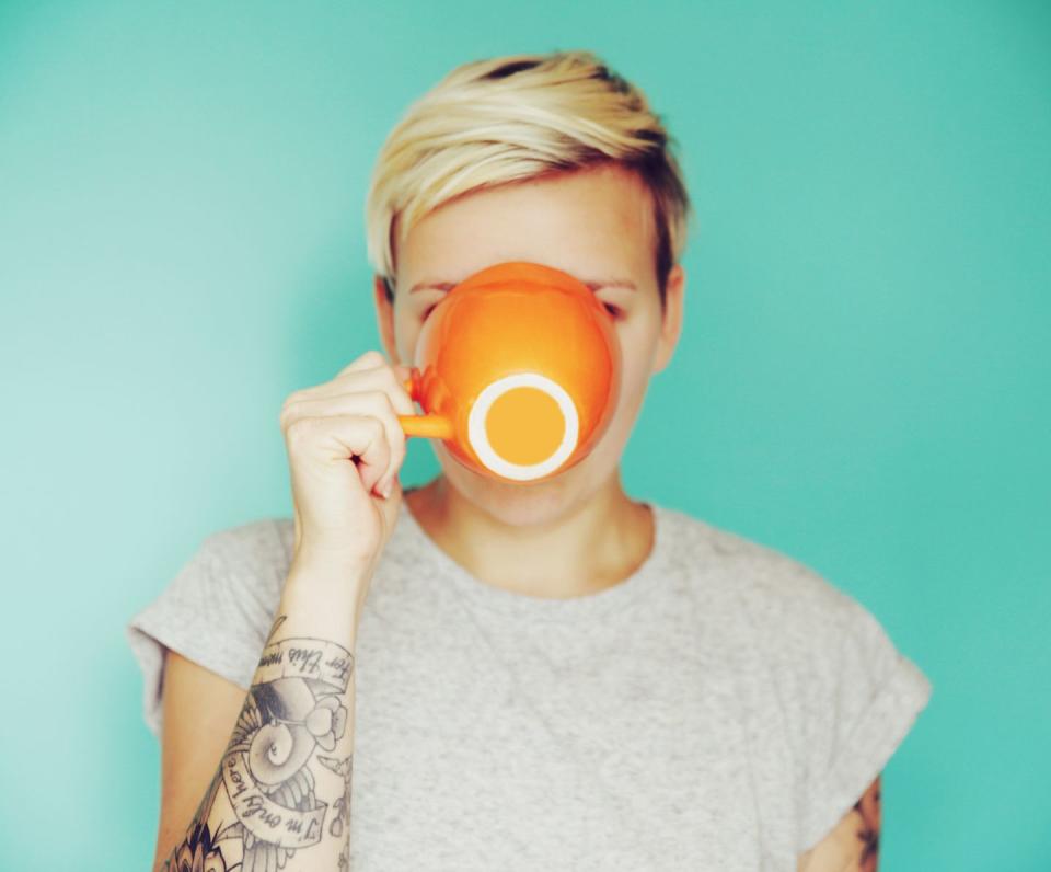 young woman drinking out of an orange cup