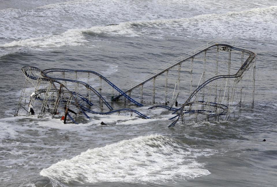 FILE - In this Wednesday, Oct. 31, 2012 file photo, waves wash over a roller coaster from a Seaside Heights, N.J. amusement park that fell in the Atlantic Ocean during superstorm Sandy. Though it’s tricky to link a single weather event to climate change, Hurricane Sandy was “probably not a coincidence” but an example of extreme weather events that are likely to strike the US more often as the world gets warmer, the U.N. climate panel’s No. 2 scientist told the Associated Press Tuesday, Nov. 27, 2012.(AP Photo/Mike Groll, File)