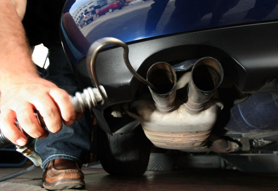 A man in California inserts a probe into the tailpipe of a car while performing an emission test.&nbsp; (Photo: Justin Sullivan via Getty Images)