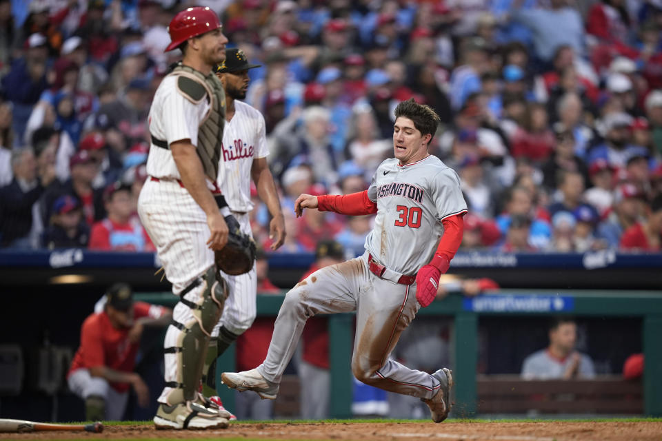 Washington Nationals' Jacob Young, right, scores past Philadelphia Phillies pitcher Cristopher Sanchez, center, and catcher J.T. Realmuto on a single by CJ Abrams during the fifth inning of a baseball game, Saturday, May 18, 2024, in Philadelphia. (AP Photo/Matt Slocum)