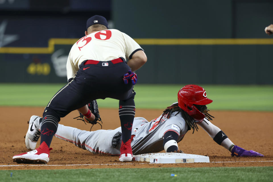 Cincinnati Reds' Elly De La Cruz beats the pickoff throw to Texas Rangers first baseman Nathaniel Lowe during the fifth inning of a baseball game Friday, April 26, 2024, in Arlington, Texas. (AP Photo/Richard W. Rodriguez)