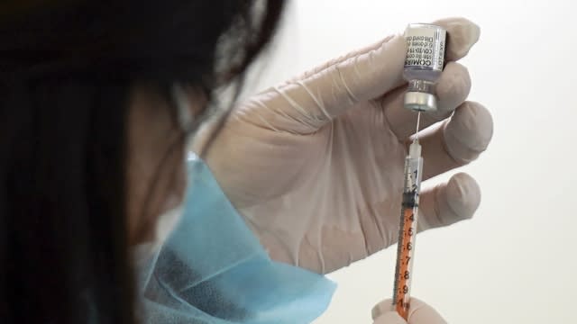 A health worker prepares a dose of the Pfizer COVID-19 vaccine in the complex of the Tokyo Skytree.