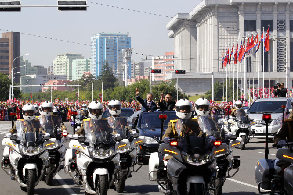 South Korean President Moon Jae-in, left, and North Korean leader Kim Jong-un ride in a car parade through Pyongyang in North Korea, Tuesday, Sept. 18, 2018. (Pyongyang Press Corps Pool via AP)