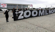 FILE - In this Jan. 8, 2021, file photo, protesters shout slogans "Vaccine now" and hold the Portuguese message "Over 200,000 deaths. The global death toll from COVID-19 has topped 2 million. (AP Photo/Eraldo Peres, File)