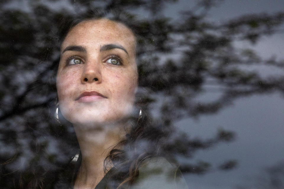 Kelsea Mensh, 22, poses for a portrait inside the lobby of a Holiday Inn Express in Dumfries, Va., Wednesday April 1, 2020, on her last day of a two week quarantine at the hotel following her evacuation from the Peace Corps in the Dominican Republic. The Peace Corps put Mensh up in a hotel in her hometown to self-isolate so that she wouldn't cause any risk to her mother, who is a cancer survivor and has viral induced asthma. Though she is grateful to have been evacuated, "I didn't get to say goodbye," says Mensh, who is very worried about the community she had to leave in the Dominican Republic. (AP Photo/Jacquelyn Martin)