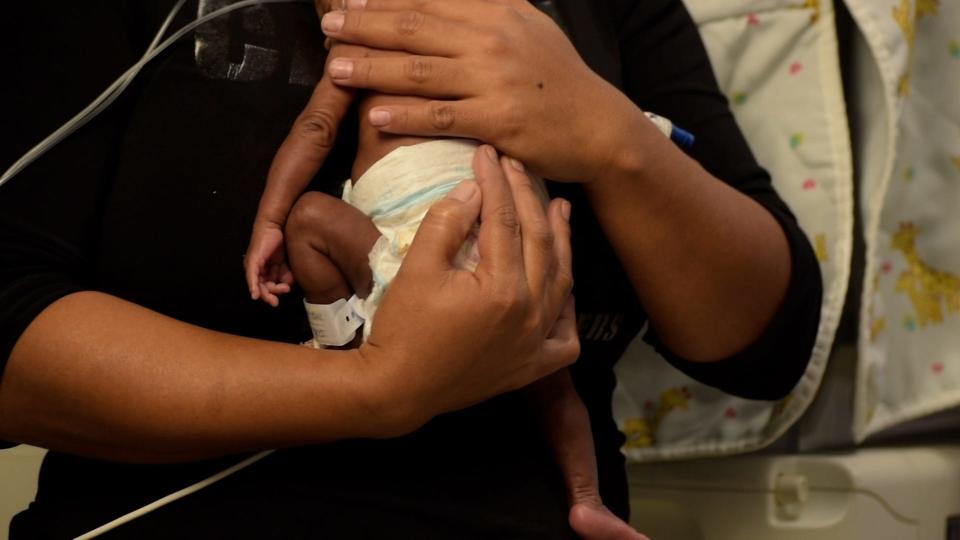 Mother holds newborn baby.