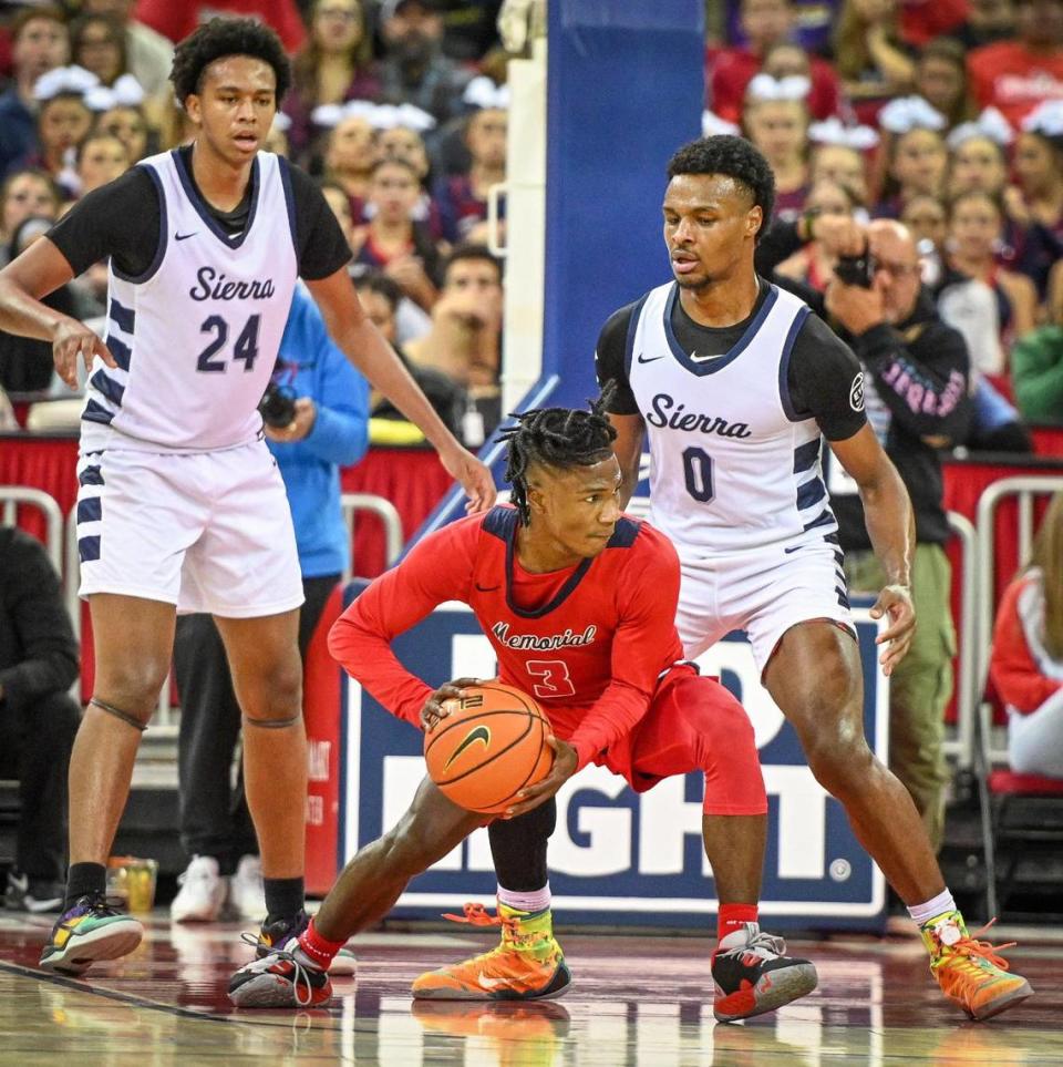 Memorial’s Armari Carraway, center, looks for an outlet as Sierra Canyon’s Ashton Hardaway, left, son of former NBA player Penny Hardaway, and Bronny James, son of current NBA player LeBron James, guard him during their game at the Save Mart Center in Fresno on Saturday, Dec. 3, 2022.