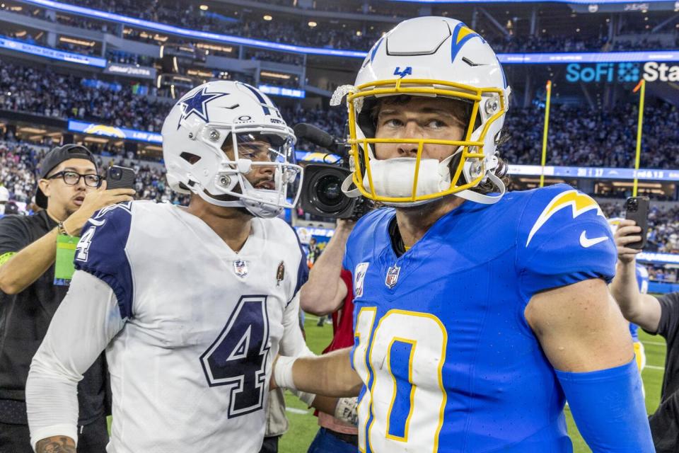 Justin Herbert and Dak Prescott on the field after the game.