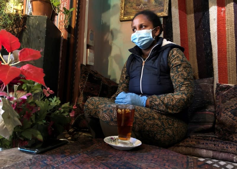 FILE PHOTO: A woman wears a mask and gloves as a measure to combat the spread of coronavirus disease (COVID-19) at a restaurant in Cape Town