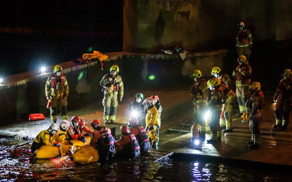 Rescue personnel work to save a small whale stranded in the River Thames -  @RICHARDFRANK