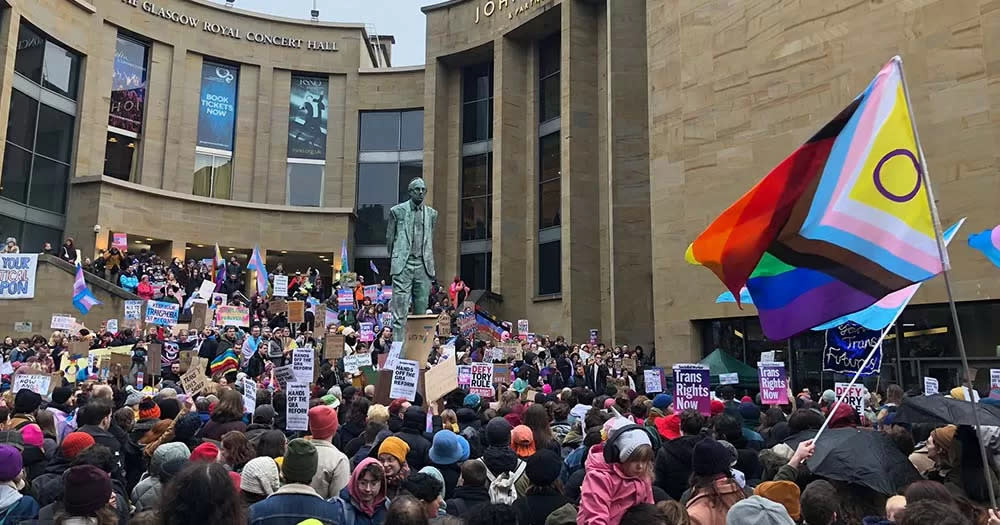 Photo of large crowd of people gathering in Scotland carrying Pride flags supporting the proposed conversion therapy ban