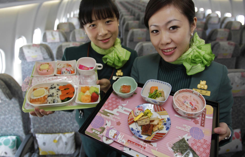 Flight attendants, holding Hello Kitty-themed in-flight meals, pose inside an Eva Airlines aircraft in Taoyuan International Airport, northern Taiwan, April 30, 2012. Taiwan's second-largest carrier, Eva Airlines, and Japan's comic company, Sanrio, which owns the Hello Kitty brand, collaborated on the second generation Hello Kitty-themed aircraft which was launched on October 2011. There are currently three Hello Kitty-themed Airbus A330-300 aircrafts flying between cities such as Taipei, Fukuoka, Narita, Sapporo, Incheon, Hong Kong and Guam. REUTERS/Pichi Chuang