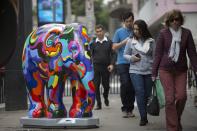 <p>Passer-by look on an elephant sculpture as part of the 'Elephant Parade' at the Paulista Avenue in Sao Paulo, Brazil, Aug. 1, 2017. (Photo: Sebastiao Moreira/EPA/REX/Shutterstock) </p>