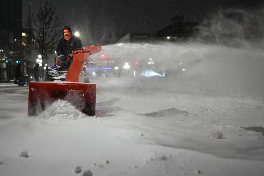 Workers get an early start clearing walkways in Sioux City, Iowa, Friday, Jan. 12, 2024. (AP Photo/Carolyn Kaster)