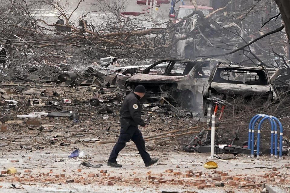 A law enforcement member walks past damage from an explosion in downtown Nashville, Tennessee, on Dec. 25, 2020.  / Credit: Mark Humphrey / AP