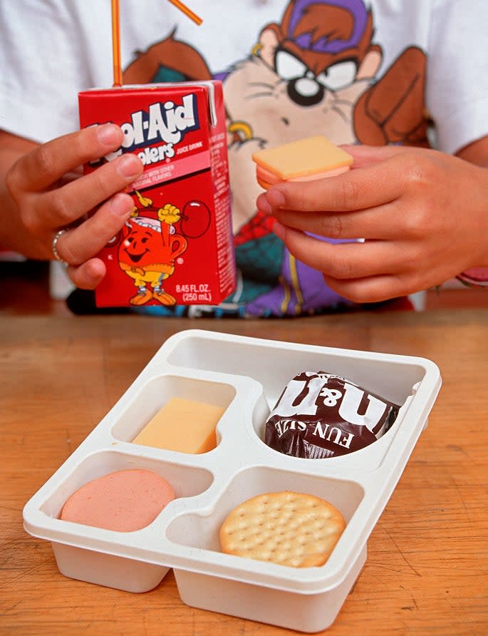 someone eating lunchables with a kool-aid juice box