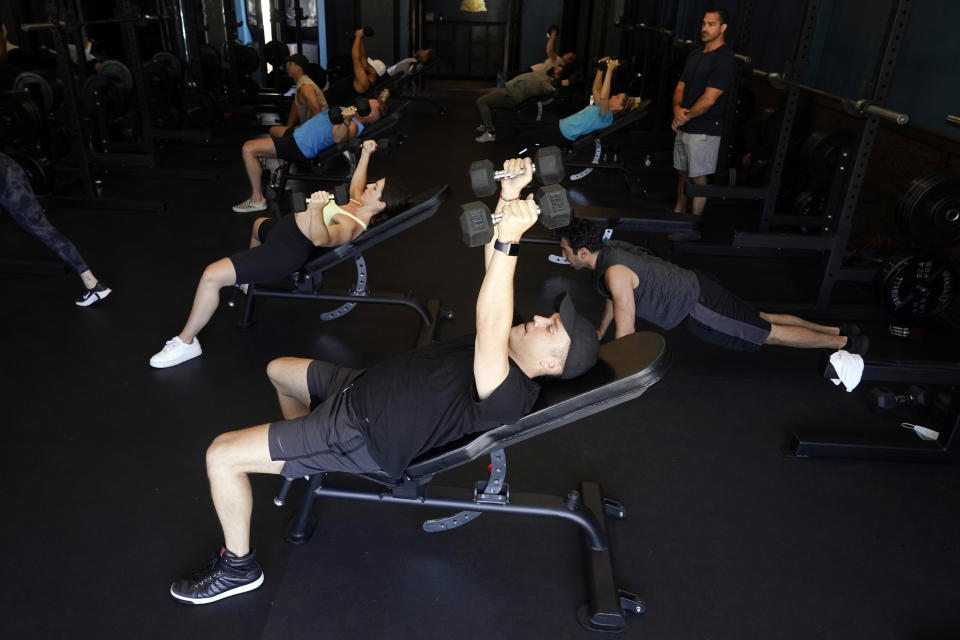 A group participates in a fitness class at Lift Society Friday, May 21, 2021, in Studio City, Calif. California's top health official says the state no longer will require social distancing and will allow full capacity for businesses when the state reopens on June 15. (AP Photo/Marcio Jose Sanchez)