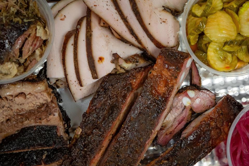 An order with mojo pork, DemKota brisket, pork spare ribs and jerk turkey bread is arranged at Tropical BBQ Market in downtown West Palm Beach.