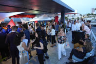 People mingle on a rooftop terrace during a pop-up tasting event for "lab-grown" meat produced by California-based Upside Foods, Thursday, June 27, 2024, in Miami. As Florida's ban on lab-grown meat is set to go into effect next week, one manufacturer hosted a tasting party, serving up cultivated chicken tostadas to dozens of attendees on a rooftop in Miami's Wynwood neighborhood. (AP Photo/Rebecca Blackwell)